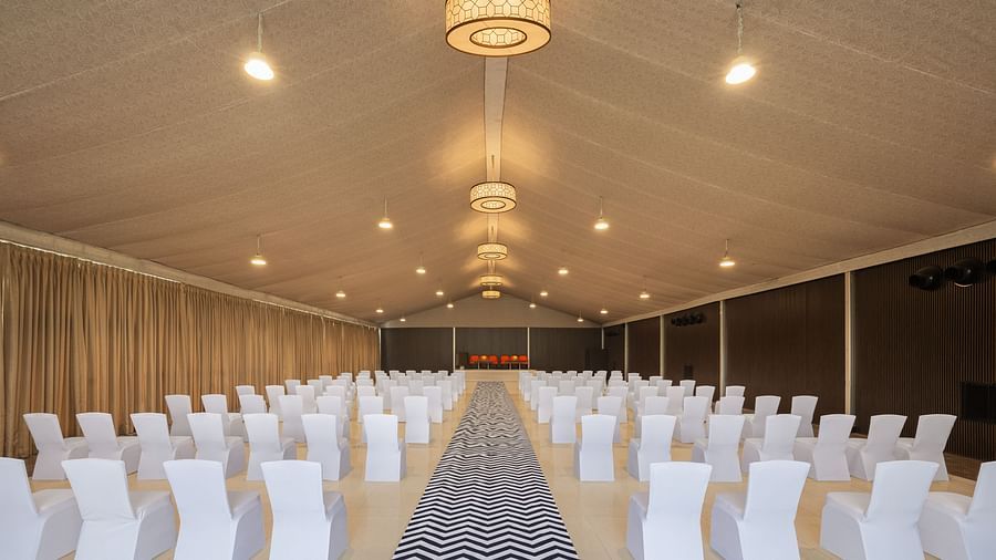 a classroom type setting with chairs placed facing the other end of the hall on each side of a pathway - The Hideaway Banquets & Lawns, Greater Noida
