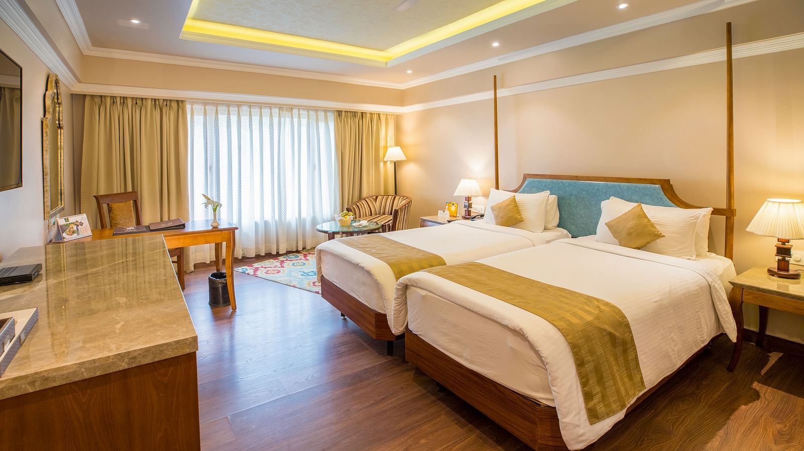 A spacious hotel room at Swosti Premium, Bhubaneswar, with two beds and a large window.