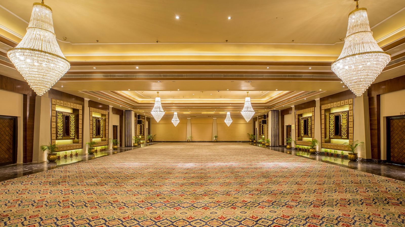 Banquet hall with various chandelier lighting creating a warm and welcoming ambiance.