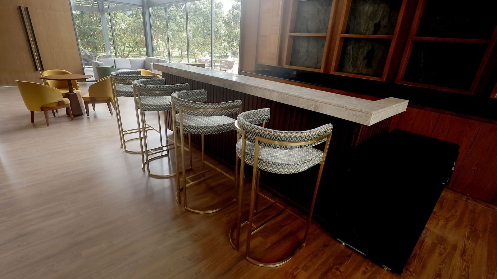 Stylish bar area with high stools and a wood-finished counter set against large windows at Wyndham Garden.