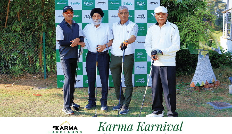 Four participants posing in front of the Karma Karnival backdrop