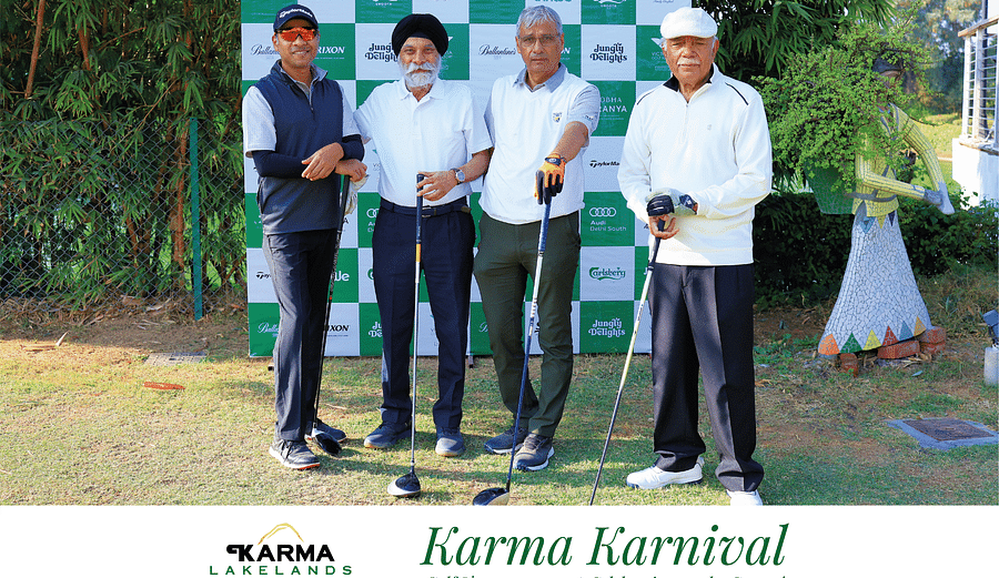Four participants posing in front of the Karma Karnival backdrop