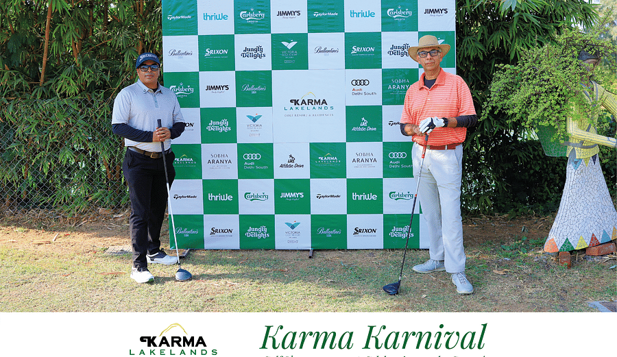 two participants posing in front of the Karma Karnival backdrop