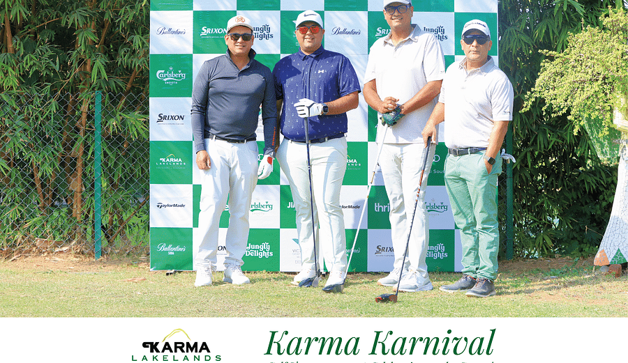 A few players posing for a picture with the backdrop Karma lakelands