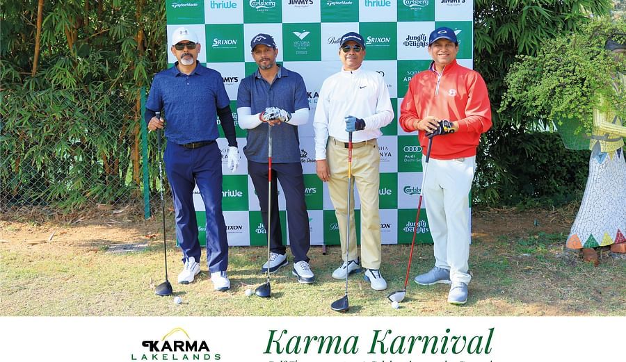 Men posing in front of the branded backdrop during Karma Karnival.