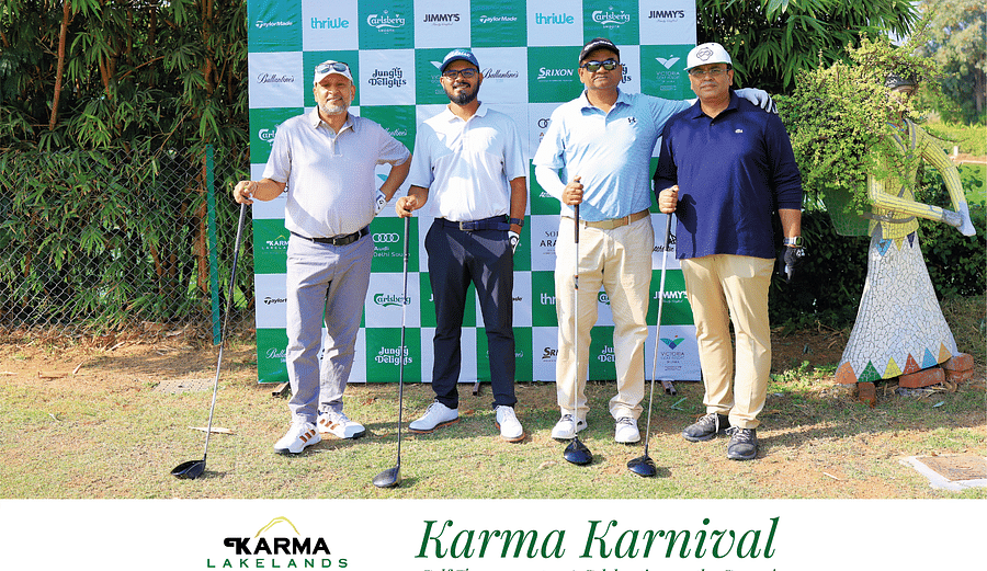 Four individuals standing in front of the Karma Karnival backdrop