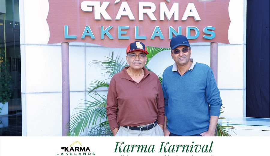 Two people standing in front of a karma lakelands background.