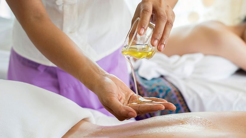 Image of a masseuse pouring oil into her hand