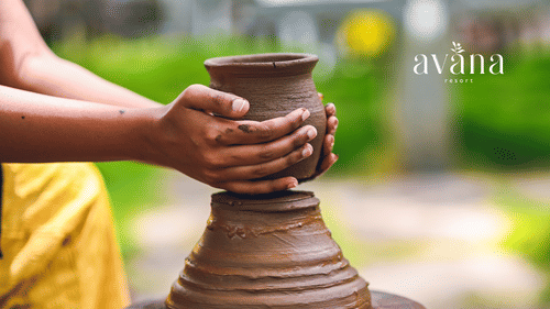 Hands shaping clay on a pottery wheel during a hands-on pottery-making session.