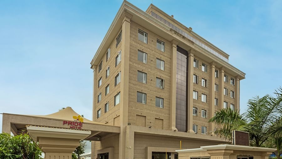 An image of Pride Hotel Bhopal Facade featuring a multi storey building surrounded by trees