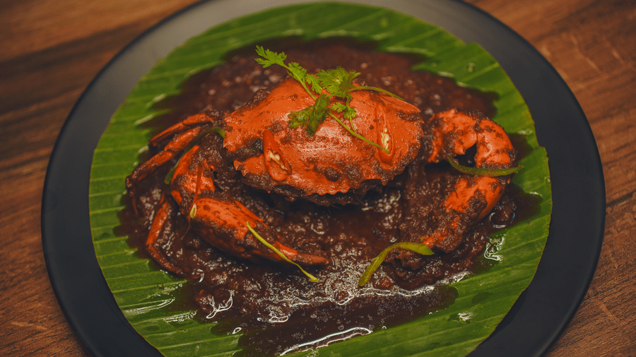 A dish plated on a banana leaf featuring whole crab smeared with spices at Dip Holidays.
