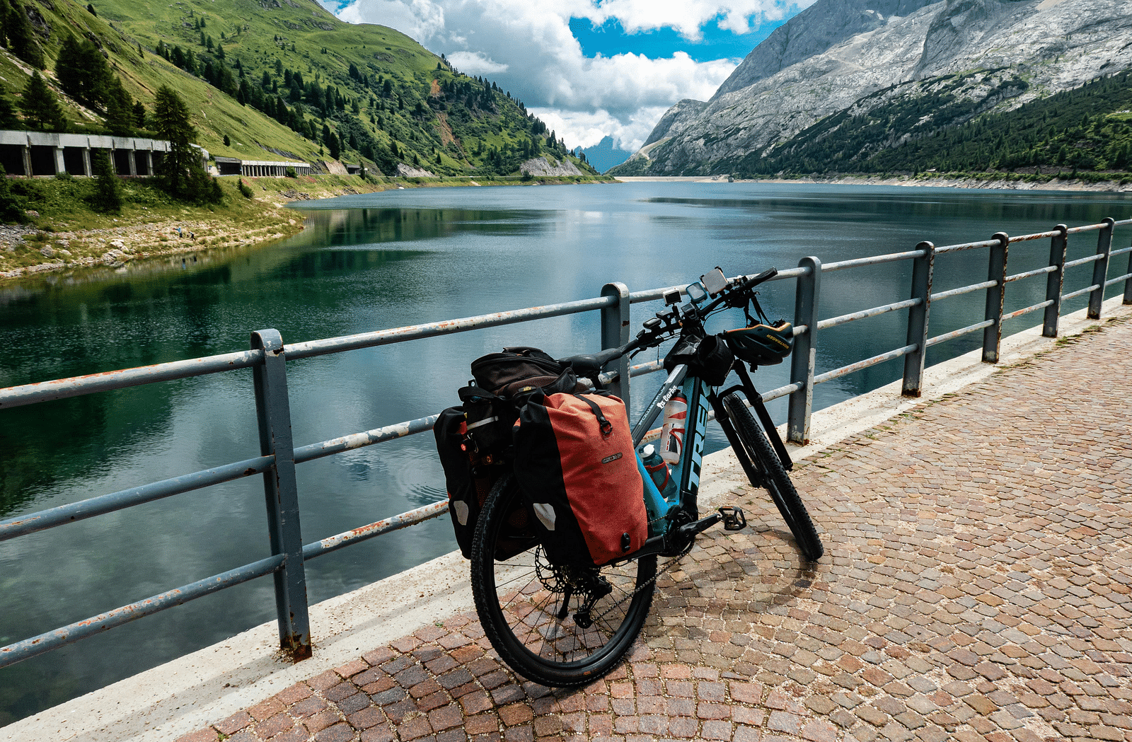 image of a cycle parked in front of a lake with mountains in the side