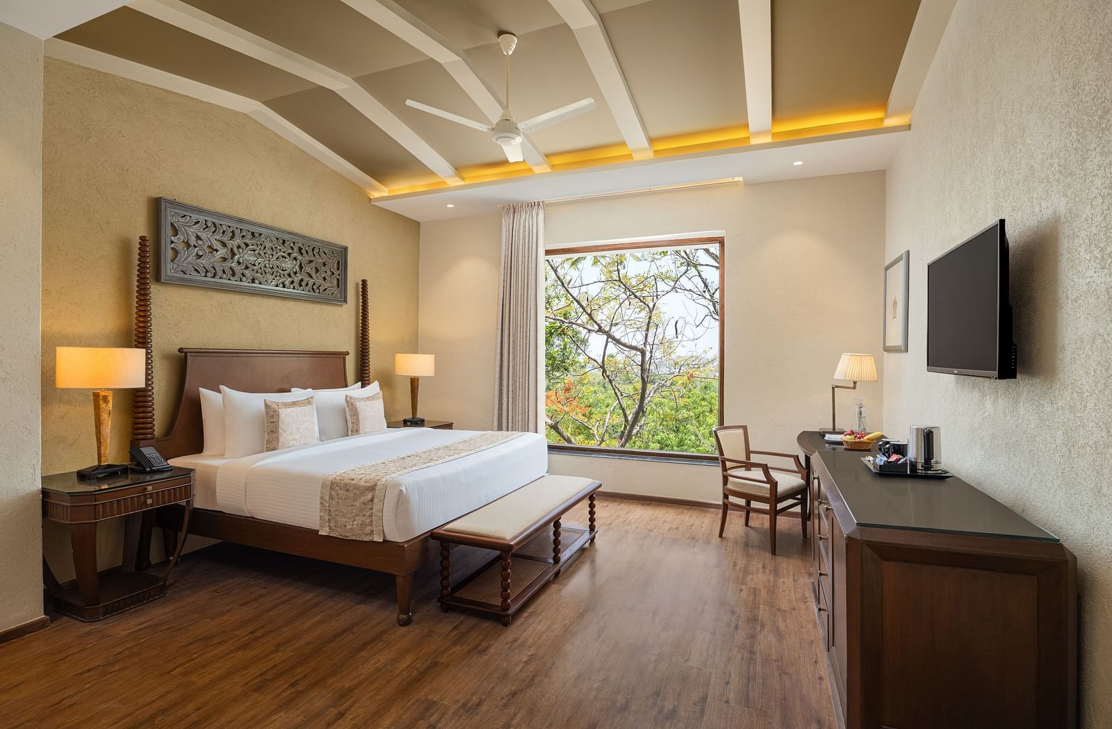 Deluxe room with a king size bed placed in front of a TV at Essentia Luxury Resort & Spa, Udaipur.