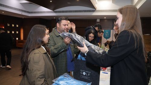 A woman handing over the package to a man in an exhibition at Heritage Village Resorts & Spa