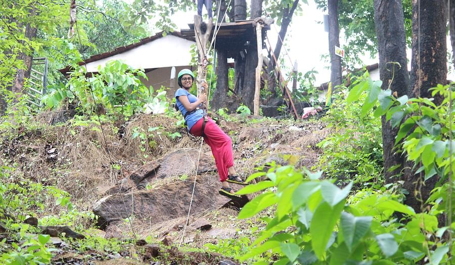 Zipline - Kundalika - A  woman riding down the zipline and posing for a picture.