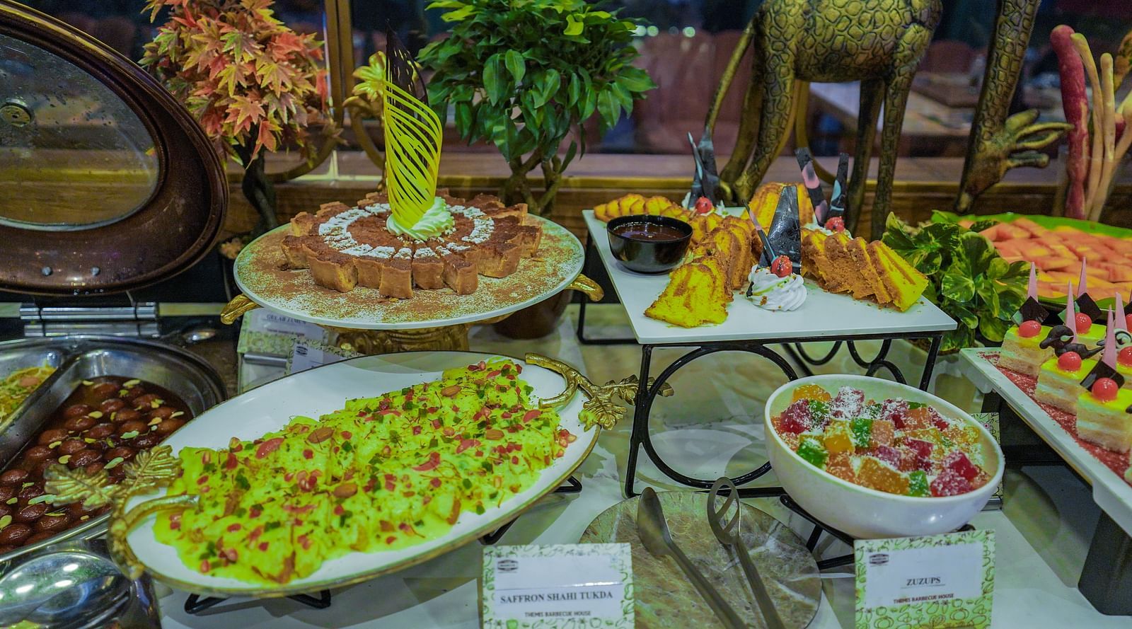 An image of a buffet where various food items are being displayed on platters, trays, bowls, etc at Themis Barbecue House, NSP Pitampura