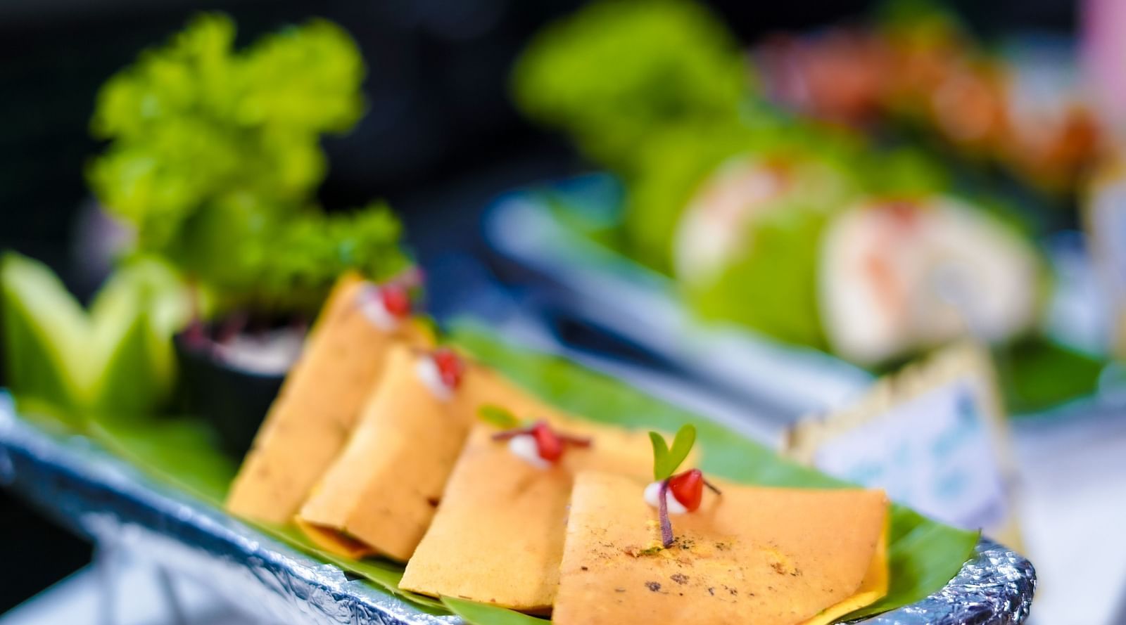 An image of dosa served in a banana leaf garnished with pomegranate and a herbal leaf - Themis Barbecue House, Panipat