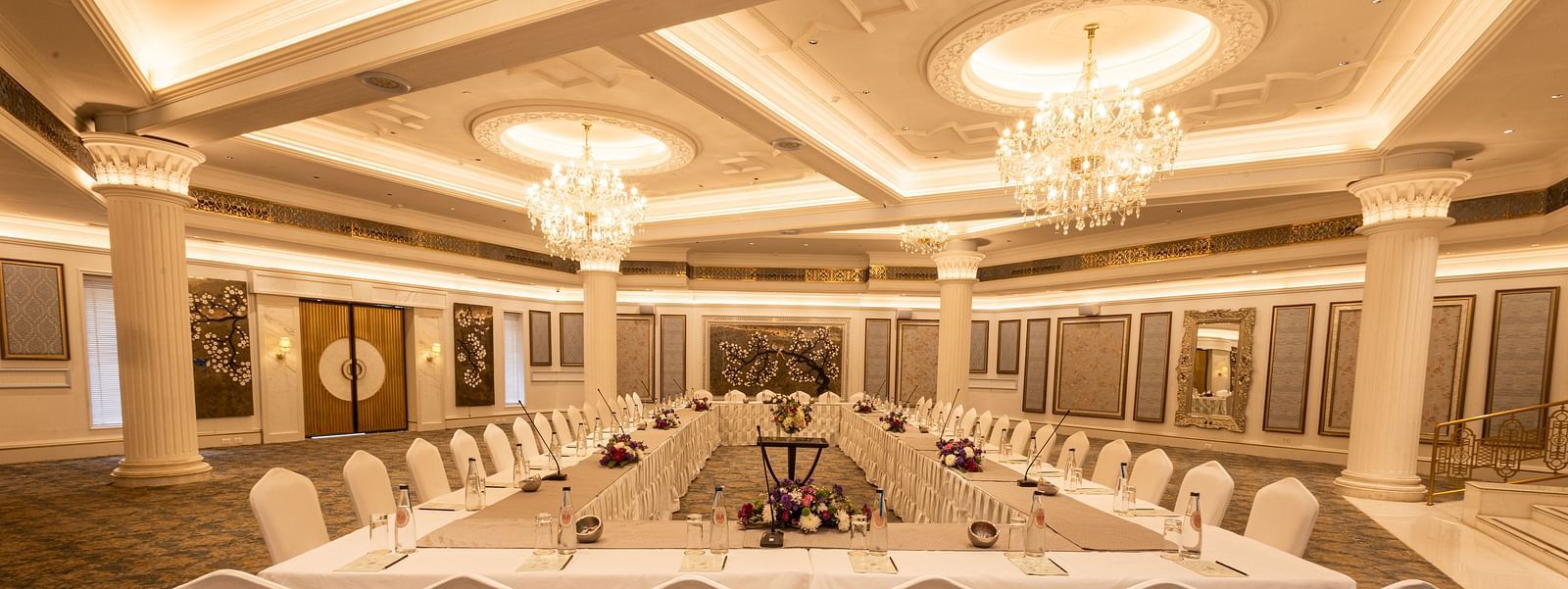 Image featuring the Viceroy Hall event venue at The Claridges New Delhi, showcasing seating arrangements and an elegant chandelier hanging overhead