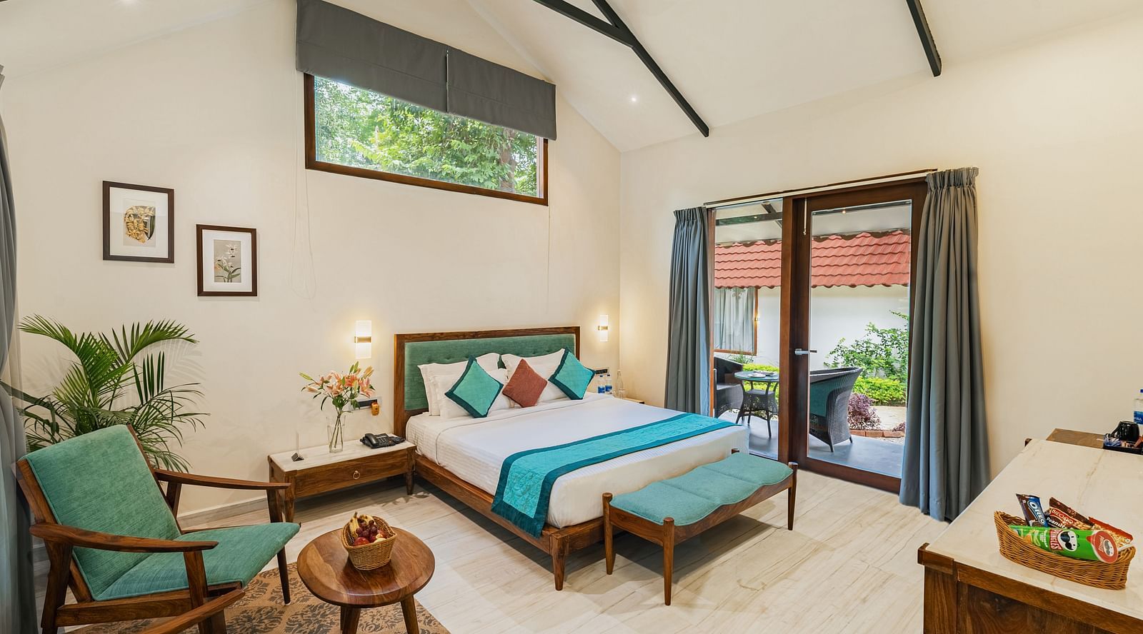 full view image from the corner of the luxury villa featuring a king size bed along with a full sized french windows at the far end of the room
