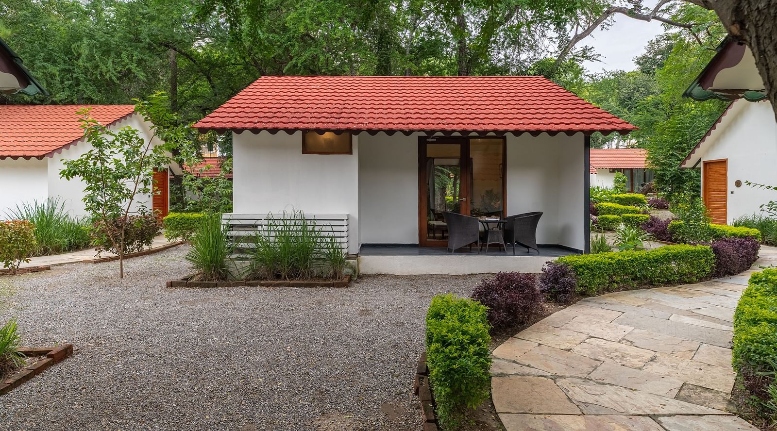 facade image of the luxury pond view villa with terracotta roof with a pathway in front of it