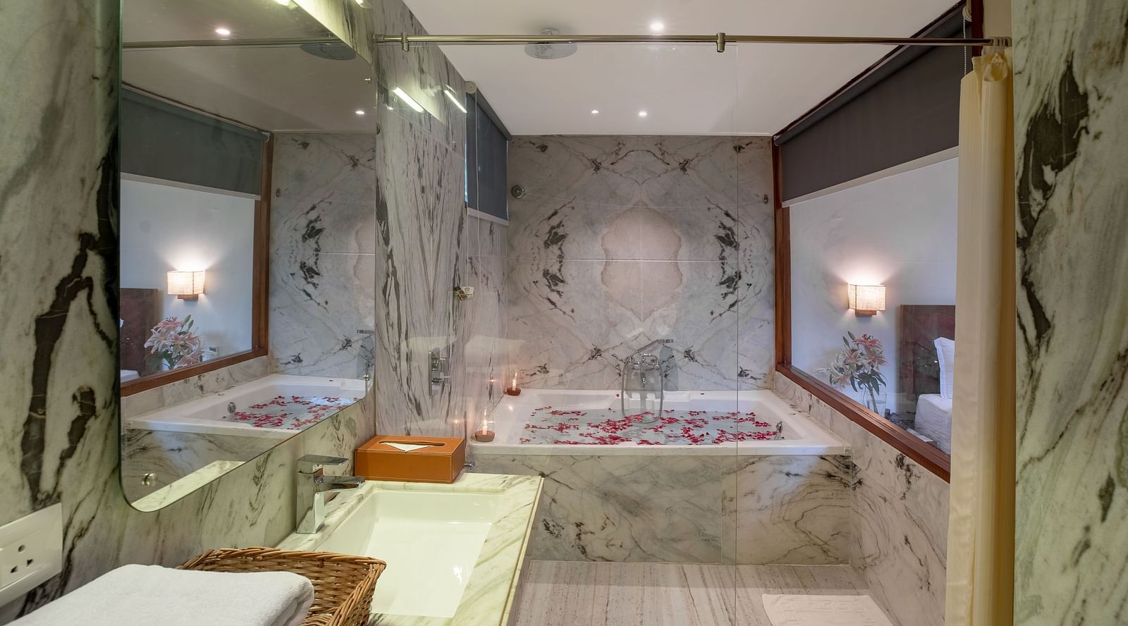 image of a well appointed bathroom at luxury bathtub villa featuring a bathtub with rose petals spread in the water 
