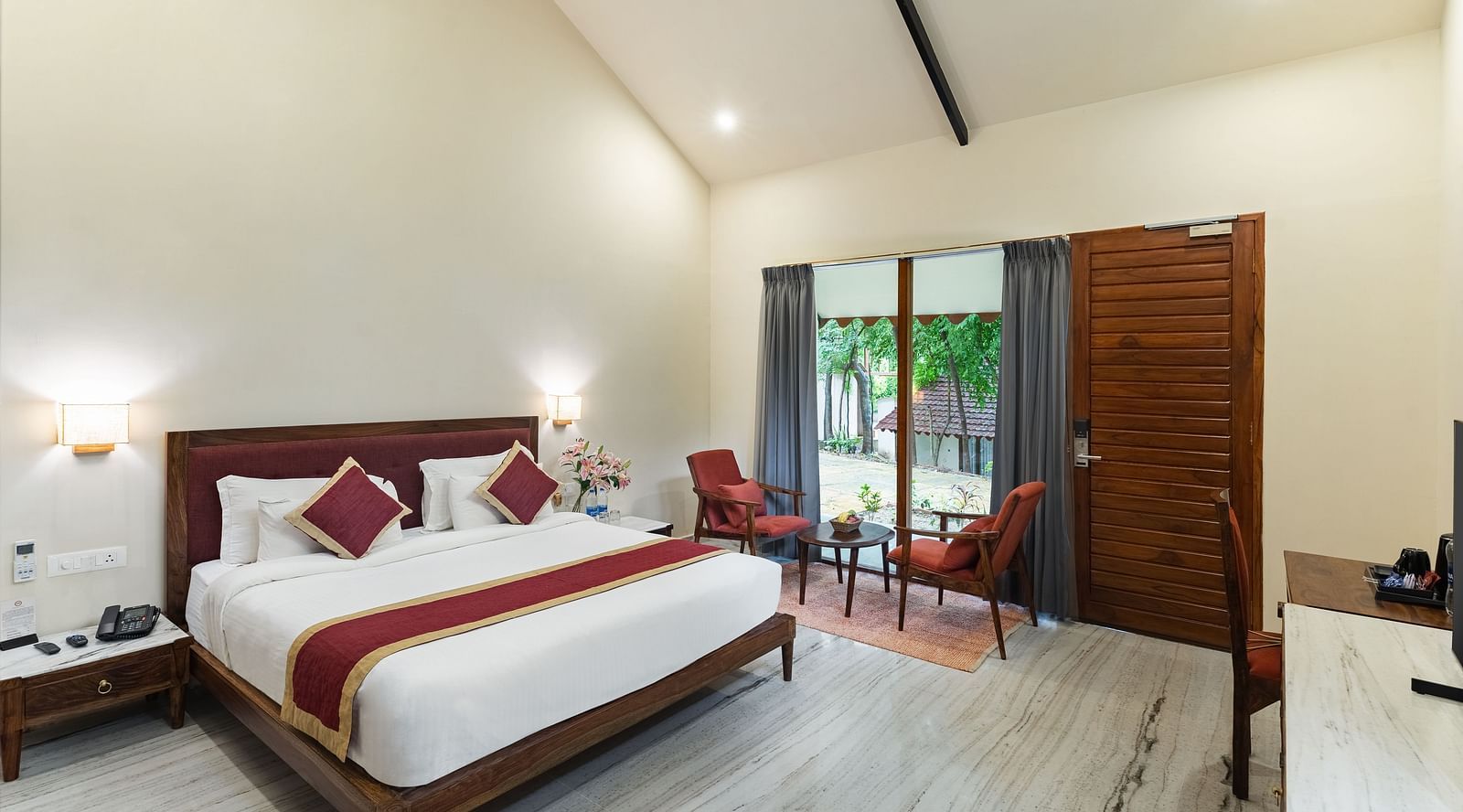 image of the luxury bathtub villa featuring a plush comfortable king size bed and huge french windows in the far end of the room at aranya vilas in udaipur