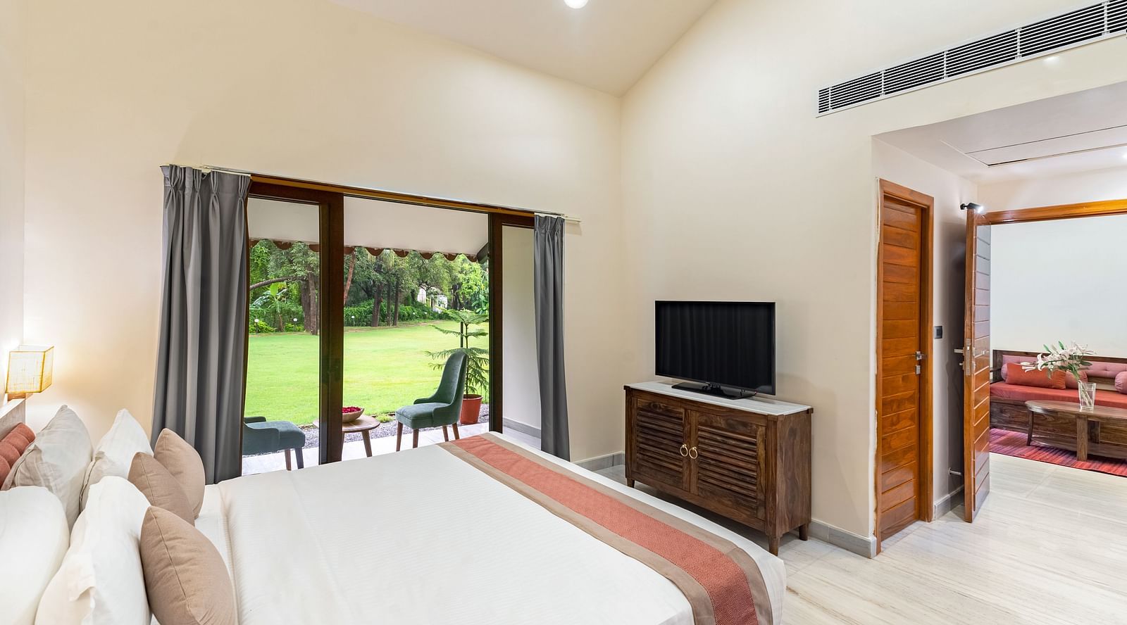 image of the bedroom in the luxury family suite featuring a king size bed with a television placed opposite to the bed at aranya vilas in udaipur
