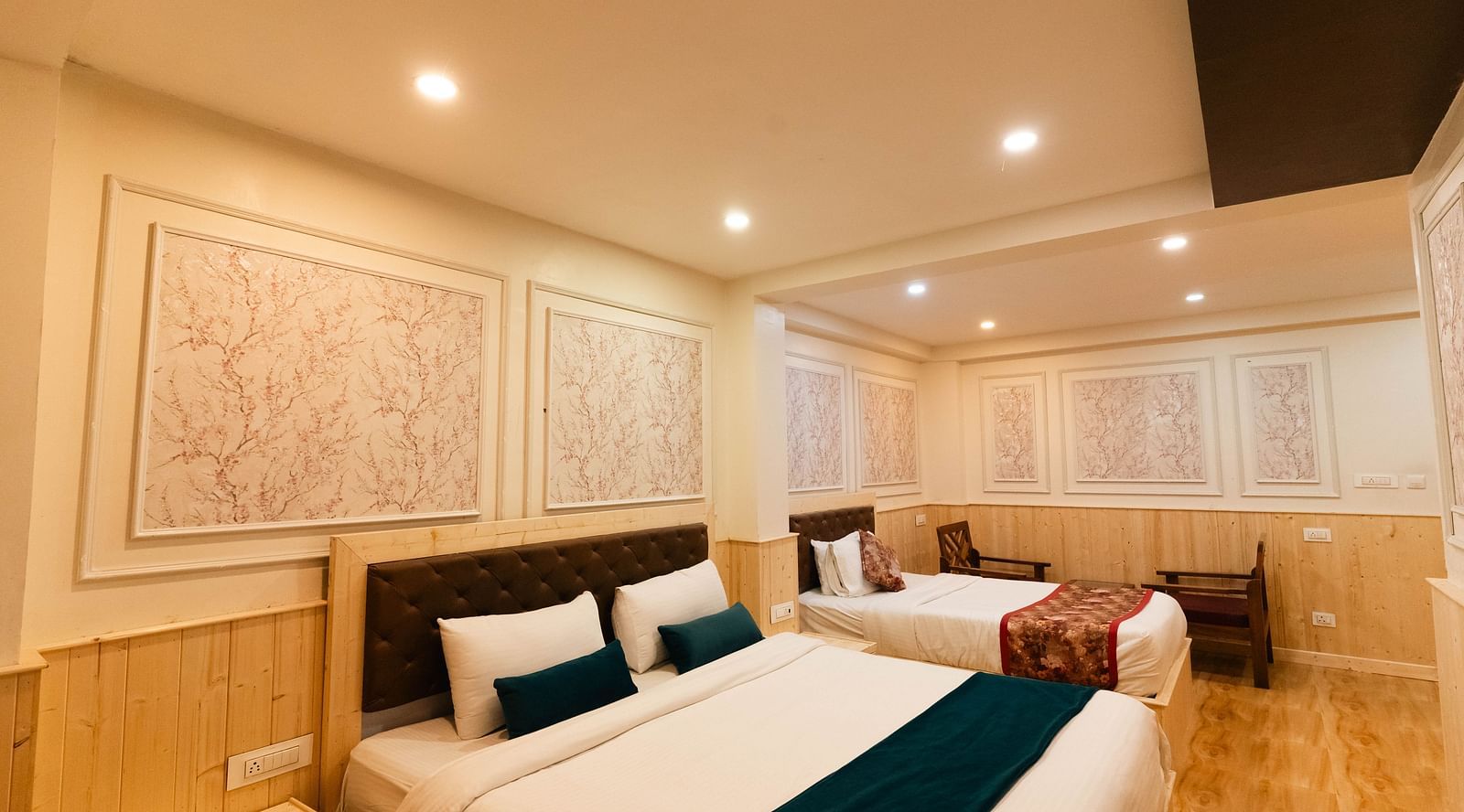 an image of a family room with two beds and two chairs at Avianna New Mandala Hotel & Spa, Darjeeling.