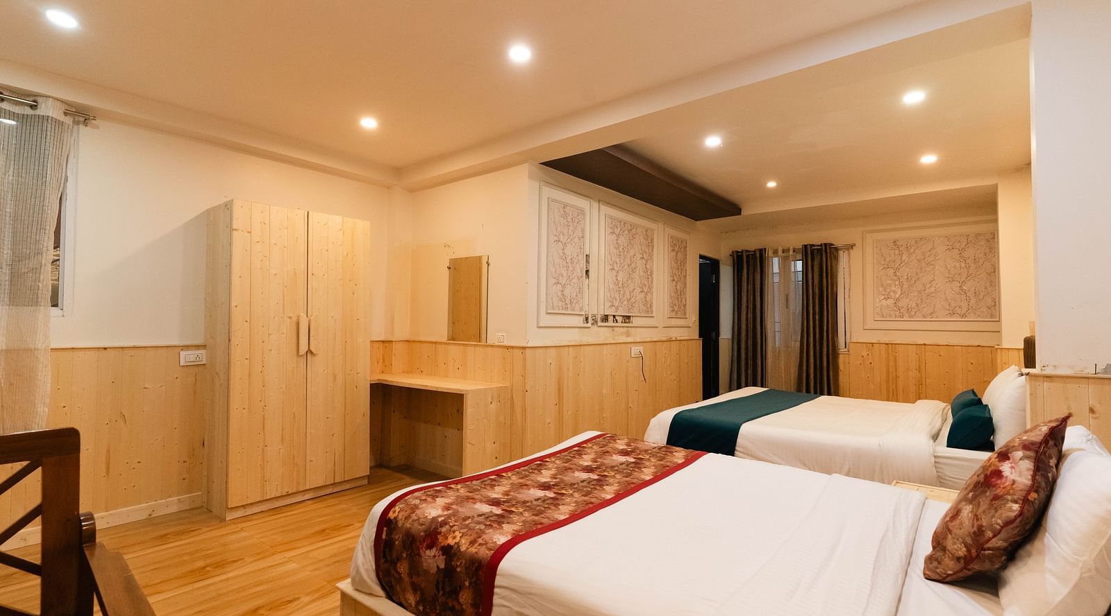 an image of a family room with two beds and wooden finished wardrobe at Avianna New Mandala Hotel & Spa, Darjeeling