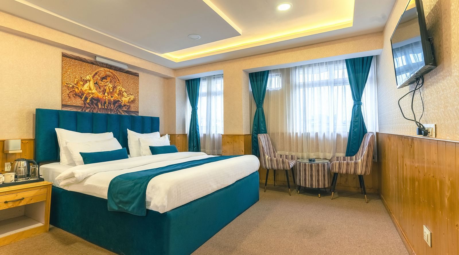 Deluxe Room Avianna Seven Seas, Deluxe Room with a king size bed, inviting ambiance, wooden bedside table, and a large window with curtains drawn along with a wall mounted television at Avianna Seven Seas, Darjeeling.