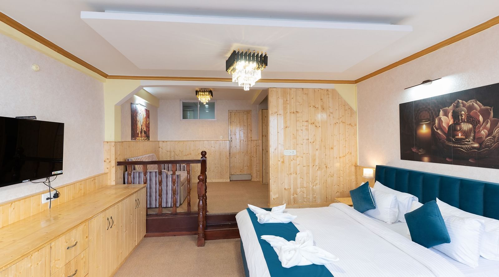 Suite with a king size bed, wall-mounted television, wooden table, and cosy lighting at Avianna Seven Seas, Darjeeling