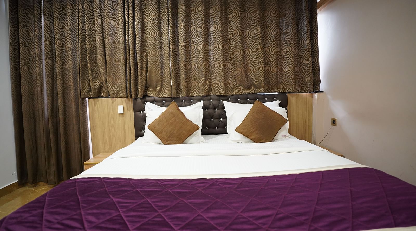 an image of close up shot of deluxe room with curtains behind the headboard
