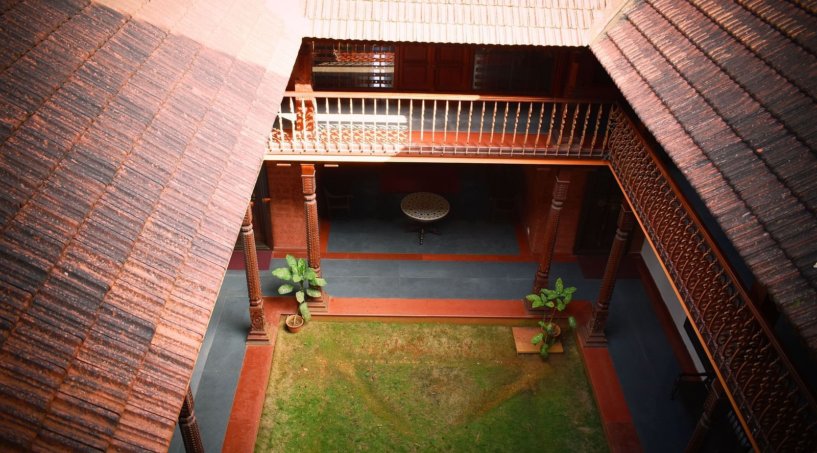 an Ariel view of the malnad attic suite featuring teracotta roof and a small garden in the middle