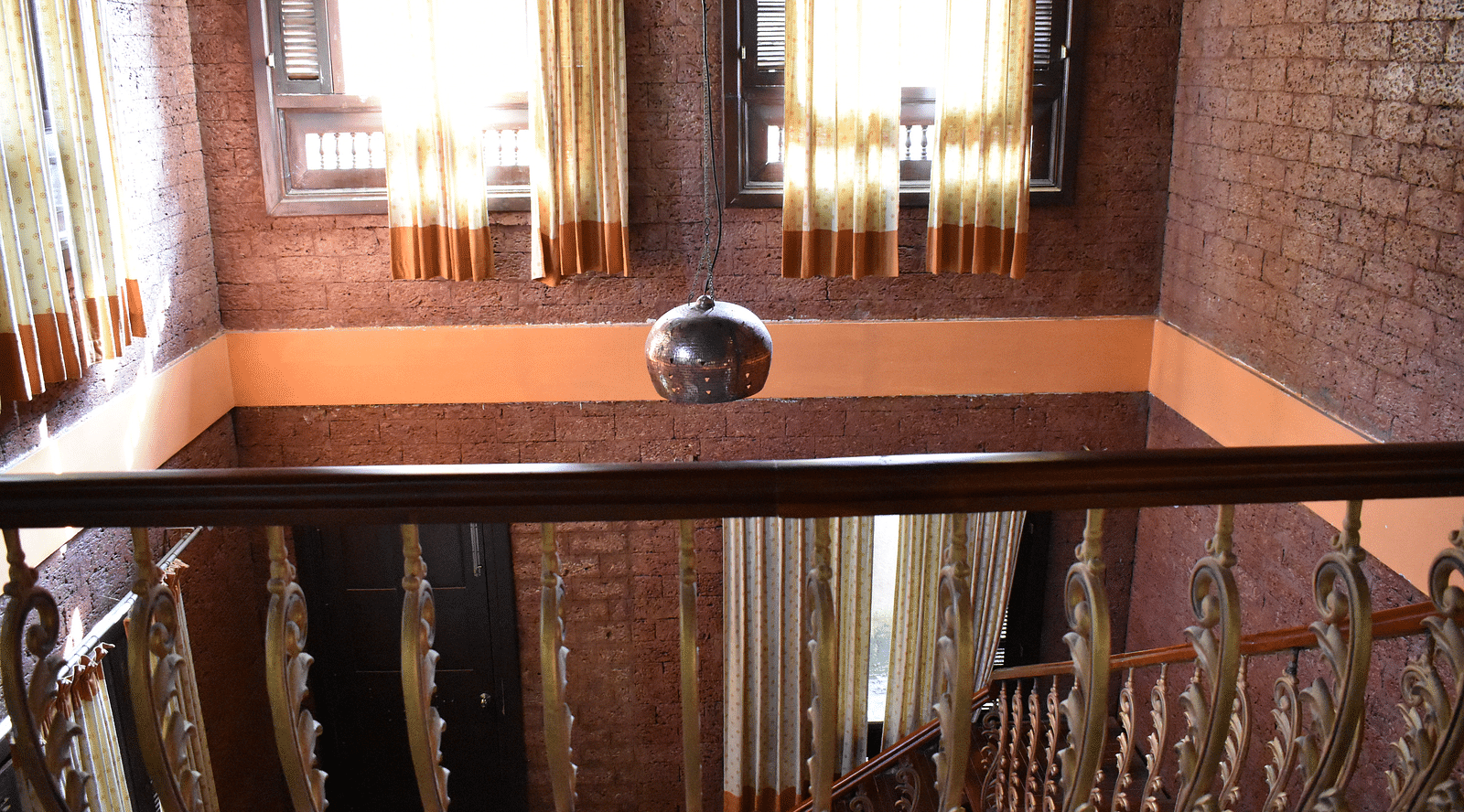 view from the first floor of the malnad palace hall going downstairs at hoysala village resort, hassan