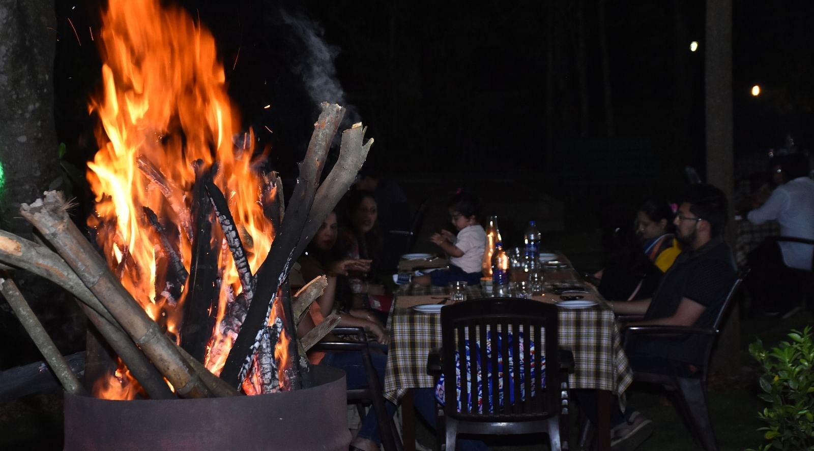 image of the garden restaurant featuring a beautiful bon fire at hoysala village resort, hassan