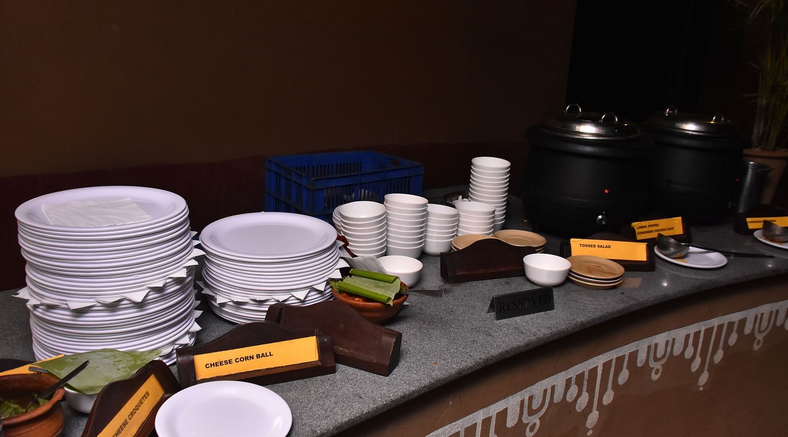 image of the buffet platter at the garden restaurant with white plates stacked up for the guests at hoysala village resort, hassan