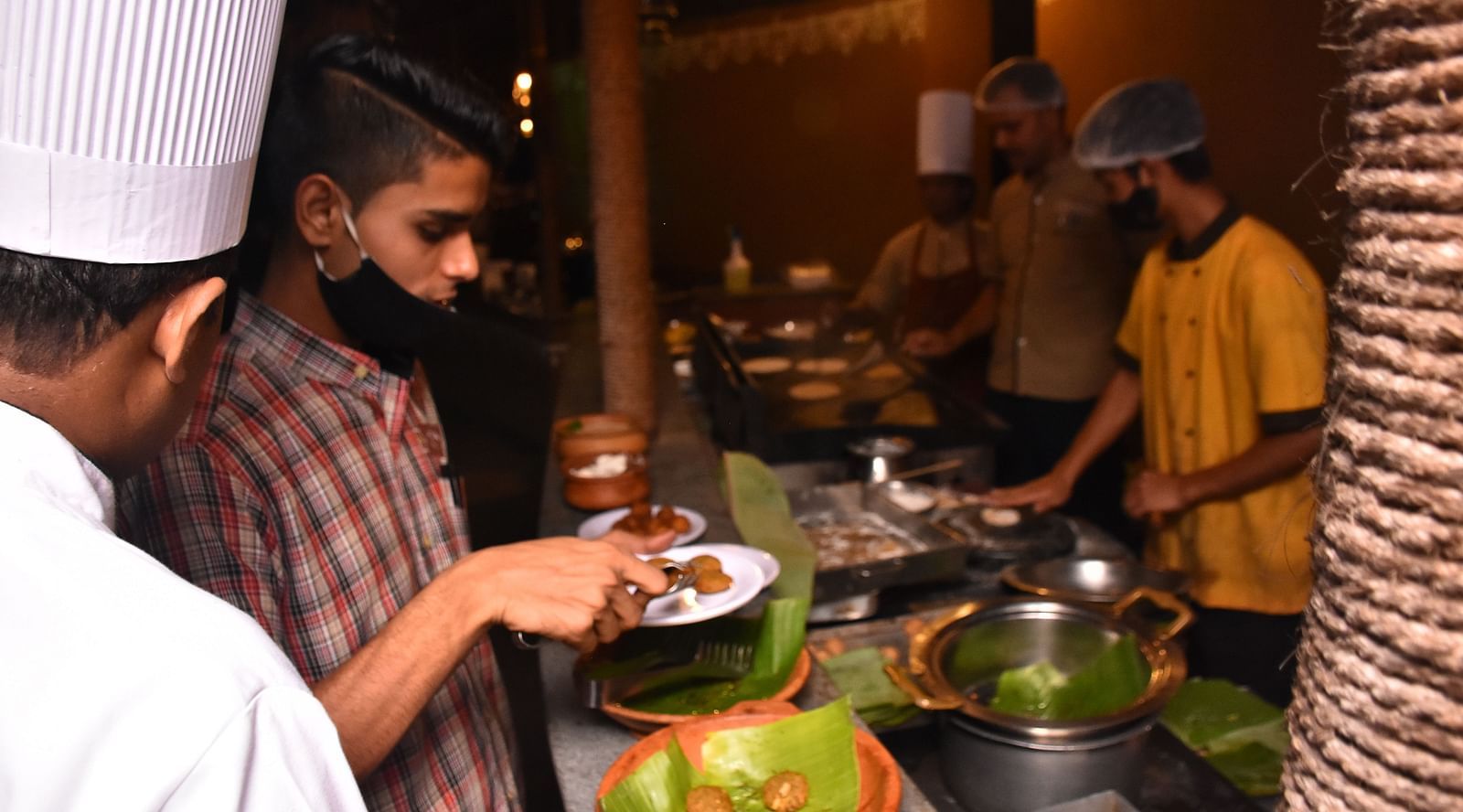 image of a person trying out dishes from the buffet at garden restaurant in hoysala village resort, hassan