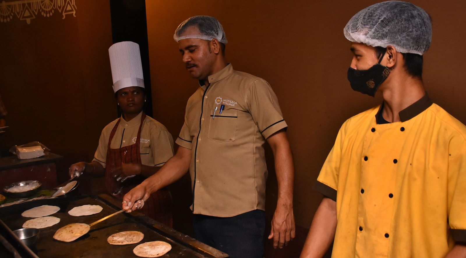 image of a group of chefs making delicious dishes for the guests at the garden restaurant at Hoysala Village Resort, Hassan