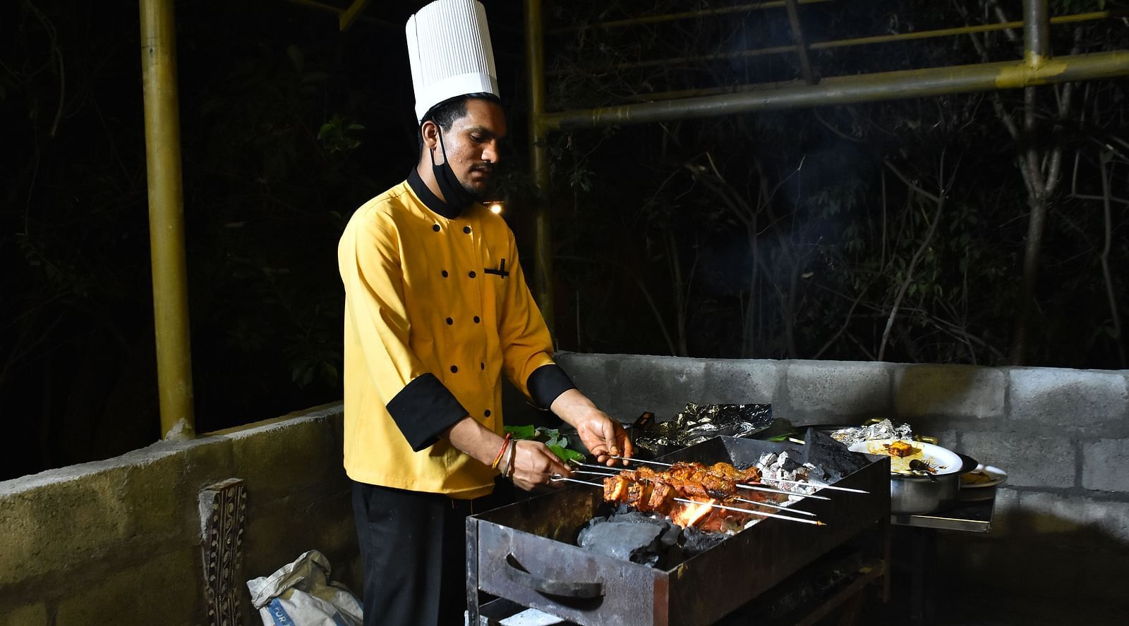 image of a chef preparing tandoori dishes on the live counter at hoysala village resort in hassan