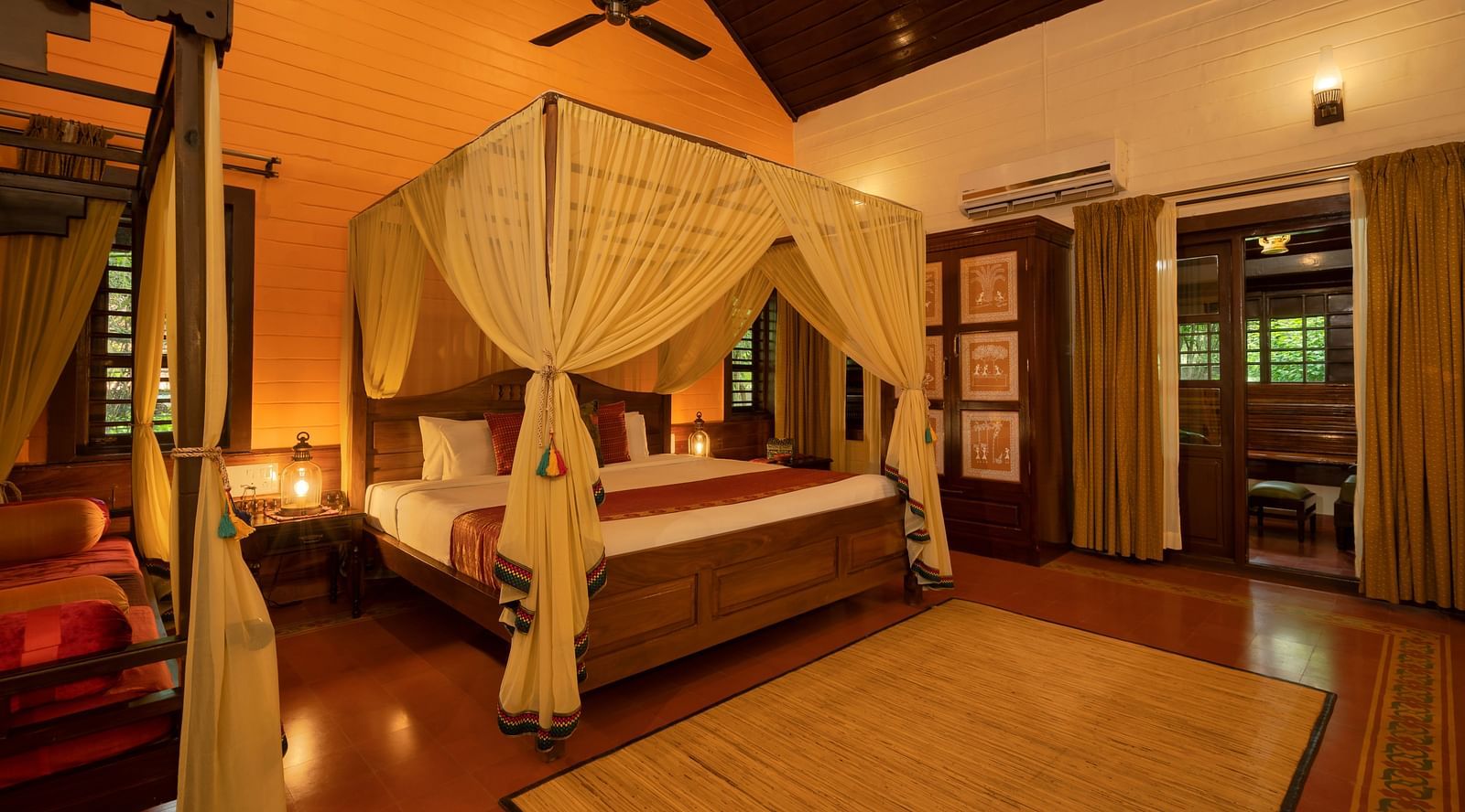 An image of a bedroom with seating area, open windows, lamp, dressing table, etc. -  Hoysala Village Resort, Hassan