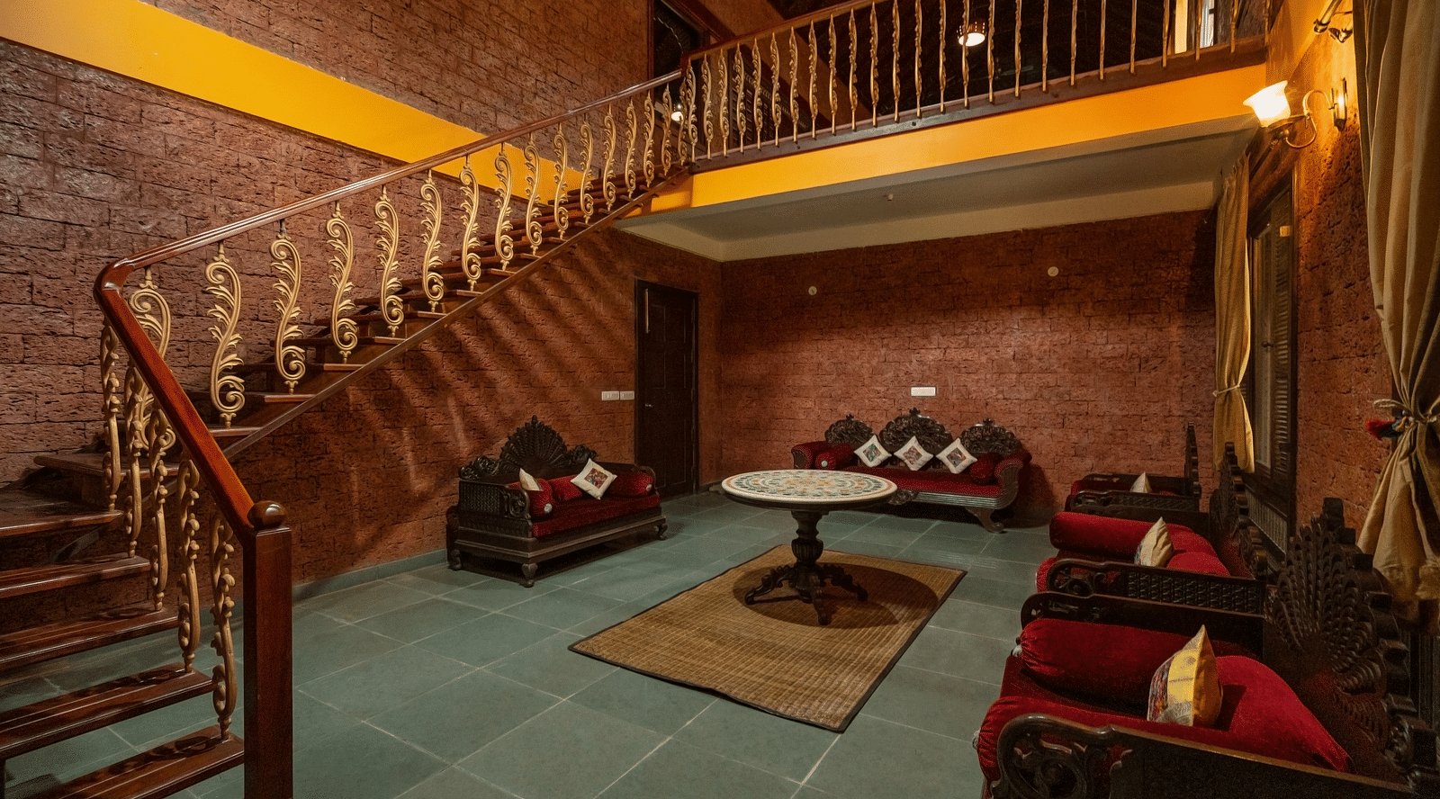 An image of a seating area and a flight of stairs on one side - Hoysala Village Resort,  Hassan