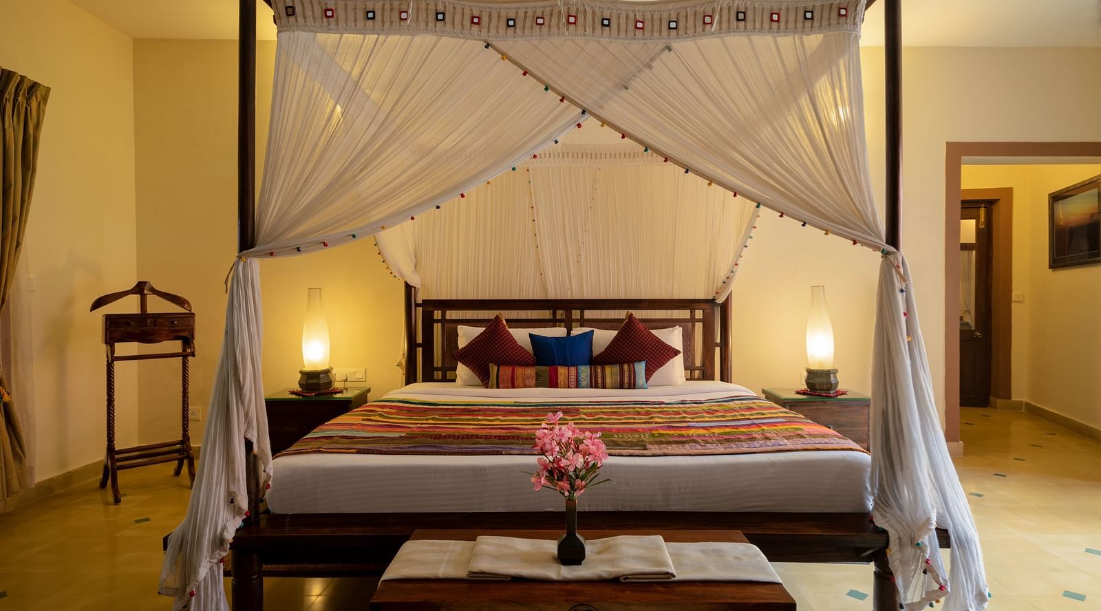 image of the four poster day bed with white cotton drapes all around it at the luxury jucuzzi villa in hoysala village resort in hassan