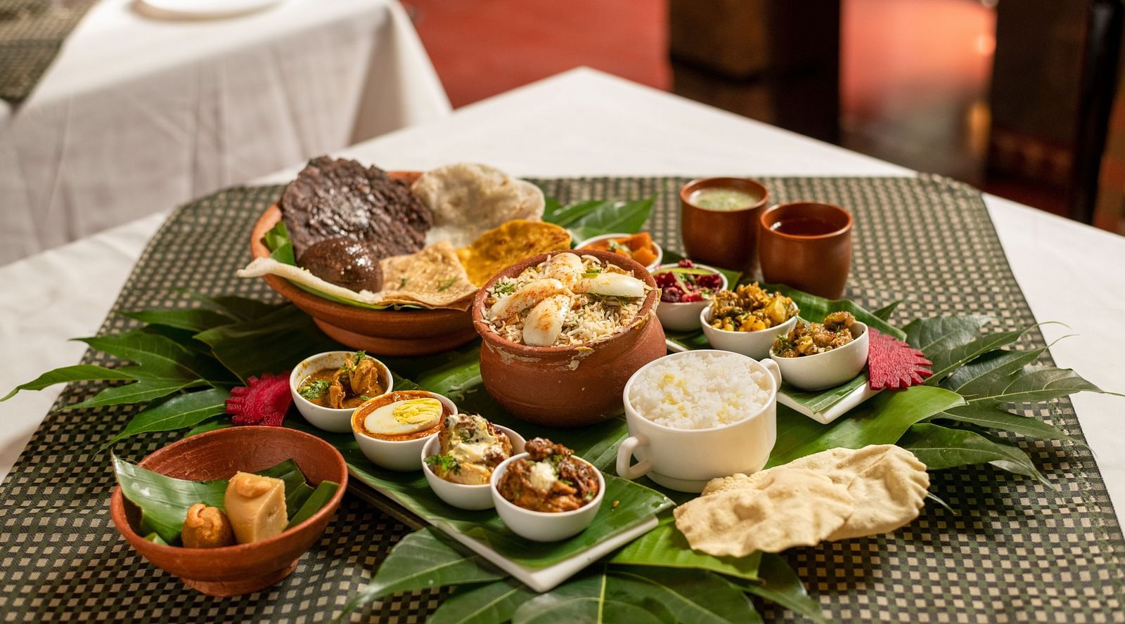 image of a full platter of food served on plantain leaves at Hoysala Village Resort, Hassan