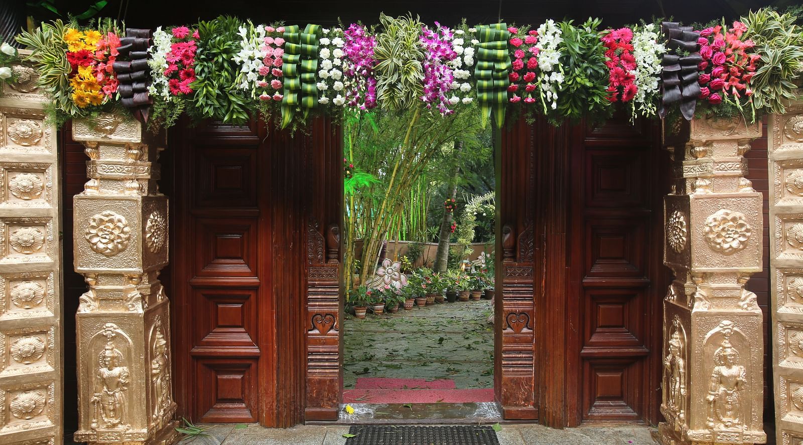 image of an entrence at hoysala village resort decorated with pillars and flowers in a very beautiful manner for a wedding
