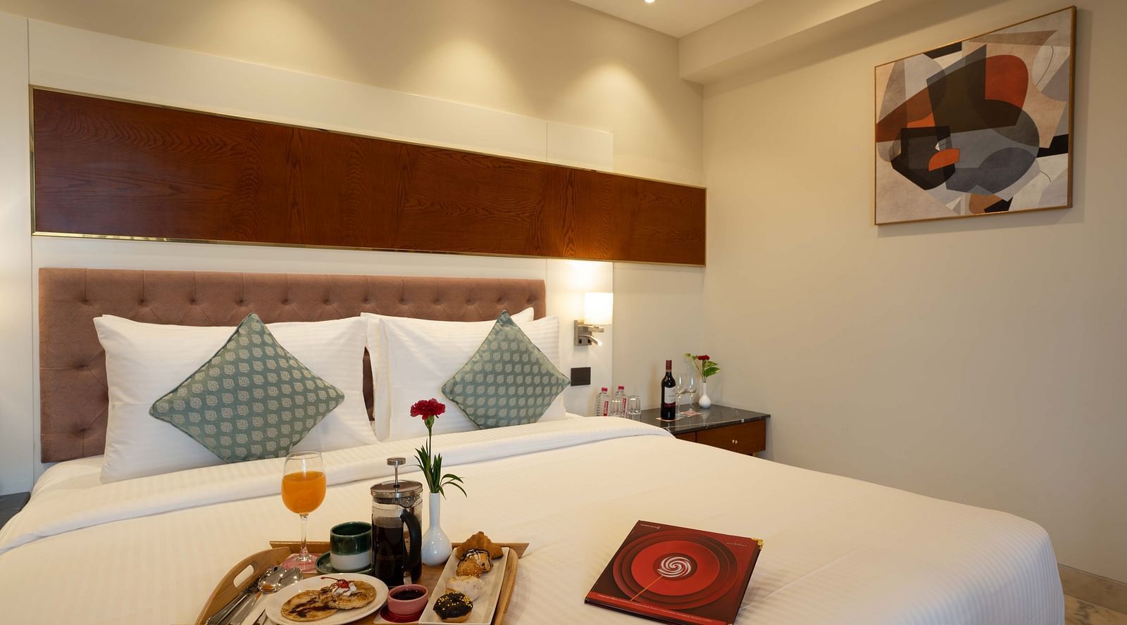 Club Room with a large double bed with decorative amenities artistically arranged at Inde Signature Jaipur.