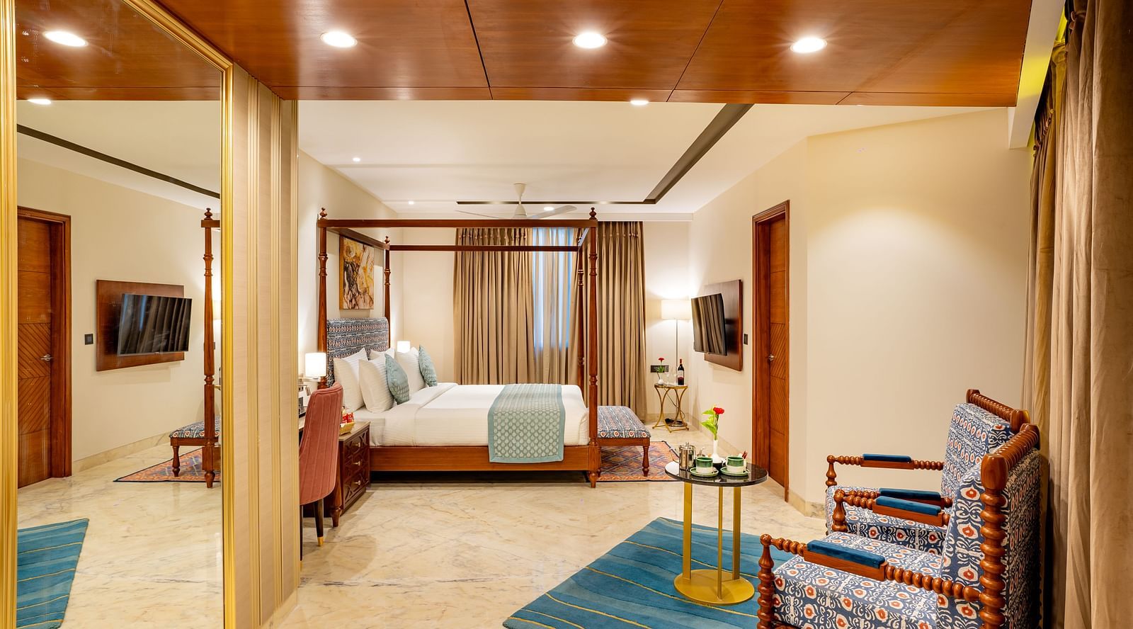 Spacious Suite with double bed, wooden bed side table, comfortable seating,wall mounted television, big window with curtains at Inde Signature Jaipur