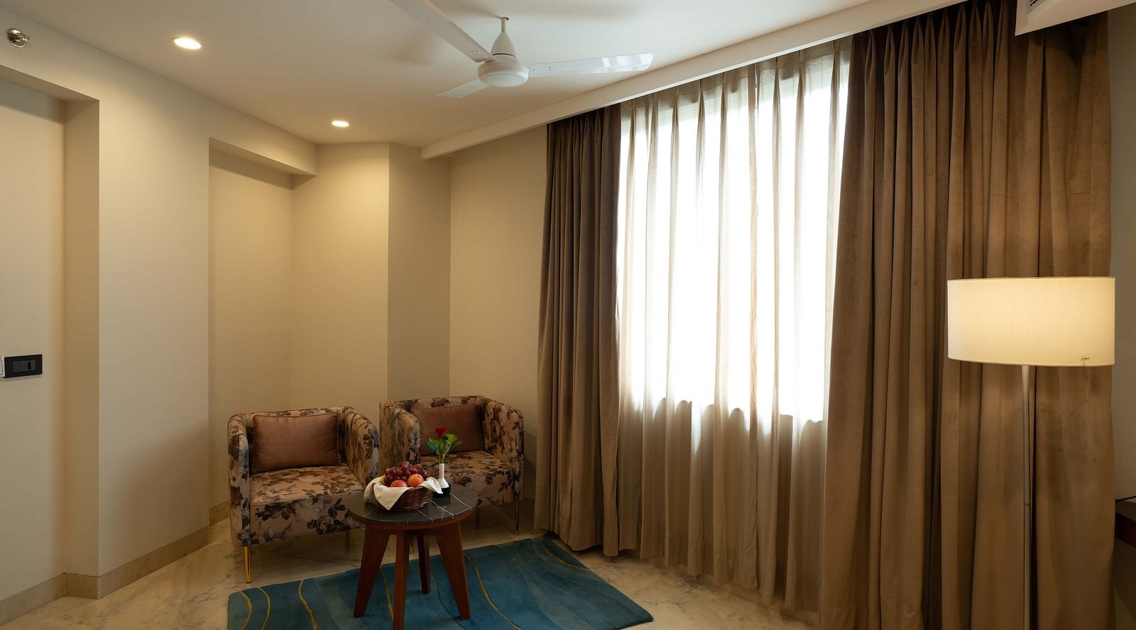 Comfortable seating next to the windows of Suite at A spacious bed with well equipped amenties in Facade view of Inde Signature Jaipur