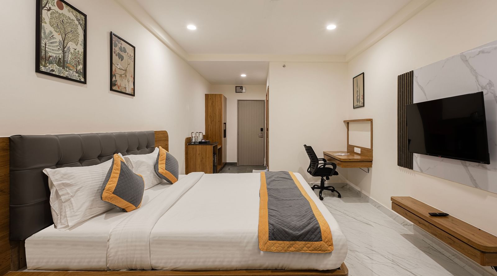 Elegant room with wall-mounted TV, work desk, and twin bedding at Lemonridge Hotels, IDPL Balanagar.