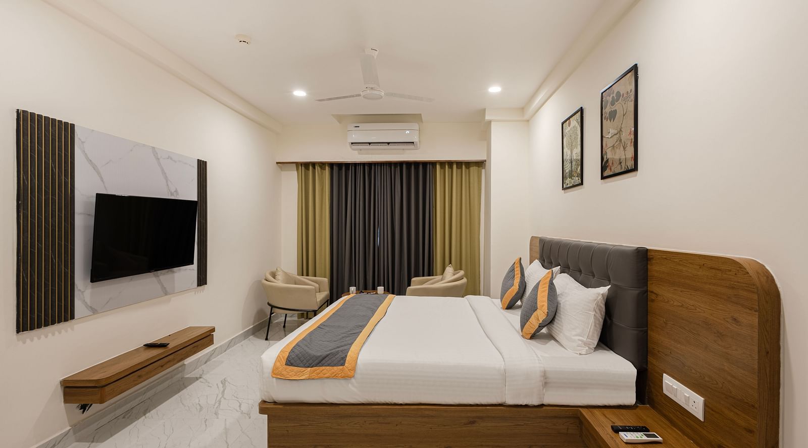 Spacious bedroom with long TV unit, king bed, and neutral décor at Lemonridge Hotels, IDPL Balanagar.