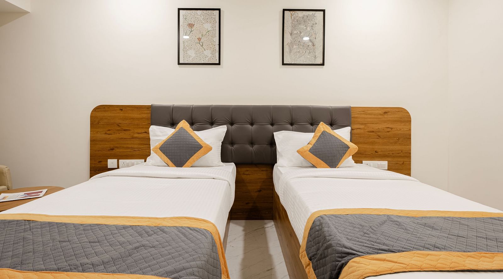 Comfortable twin-bed setup with minimal decor at Lemonridge Hotels, IDPL Balanagar